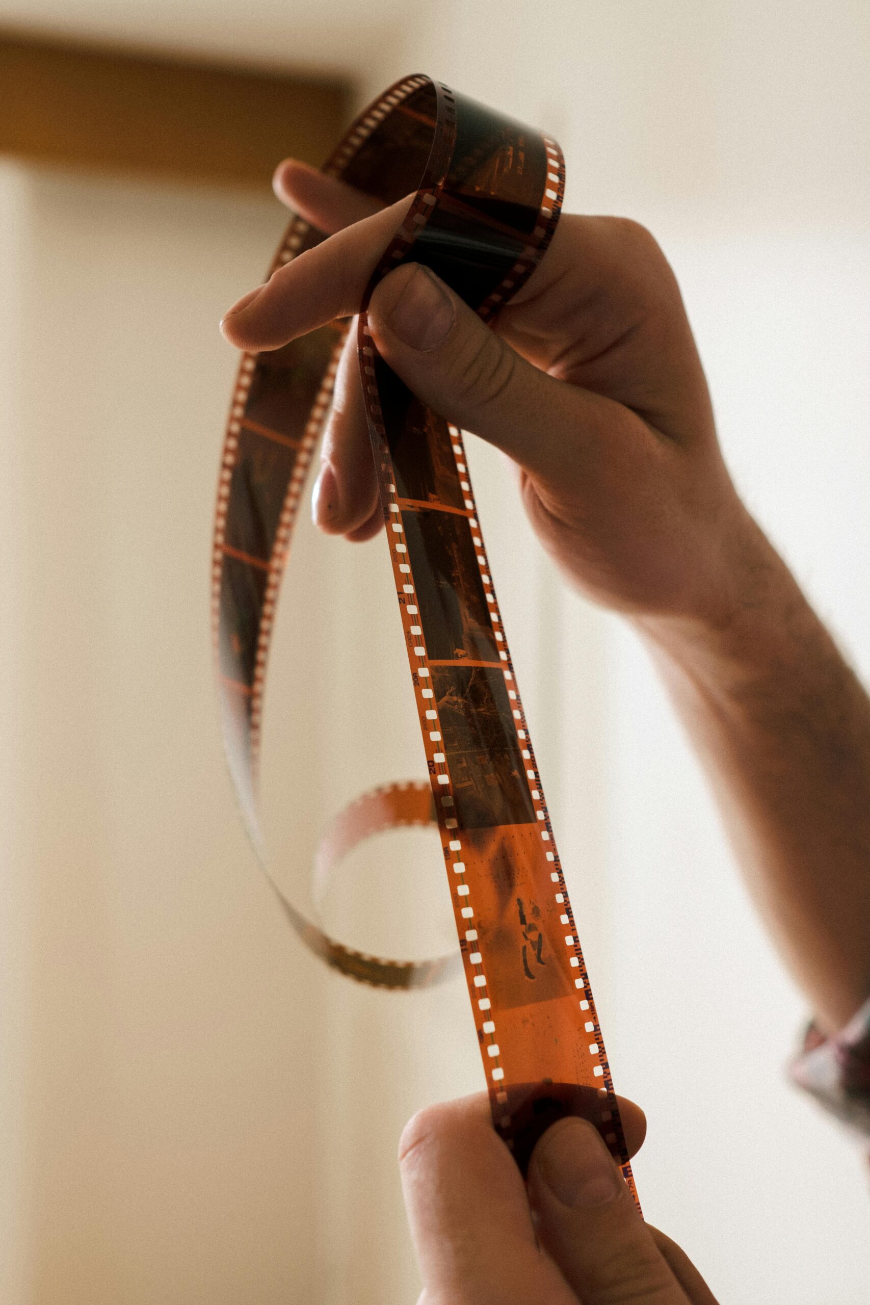 Detailed close-up of hands gently handling a film strip with selective focus.